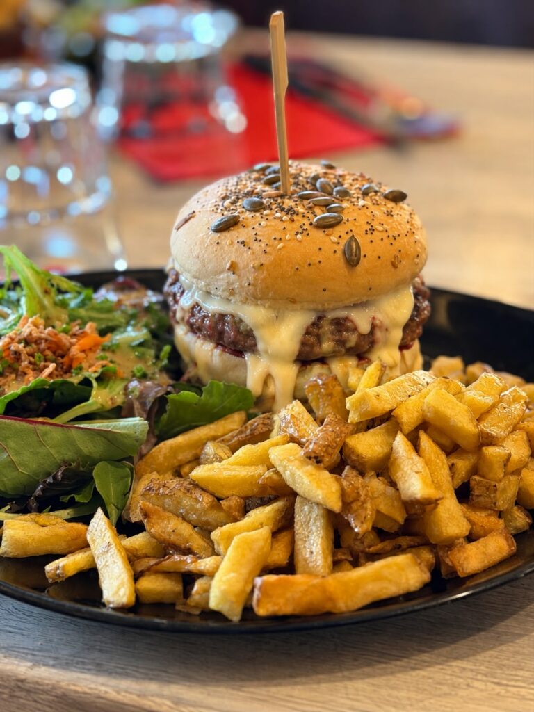 burger artisanal avec du fromage affiné coulant, accompagné de frites maison